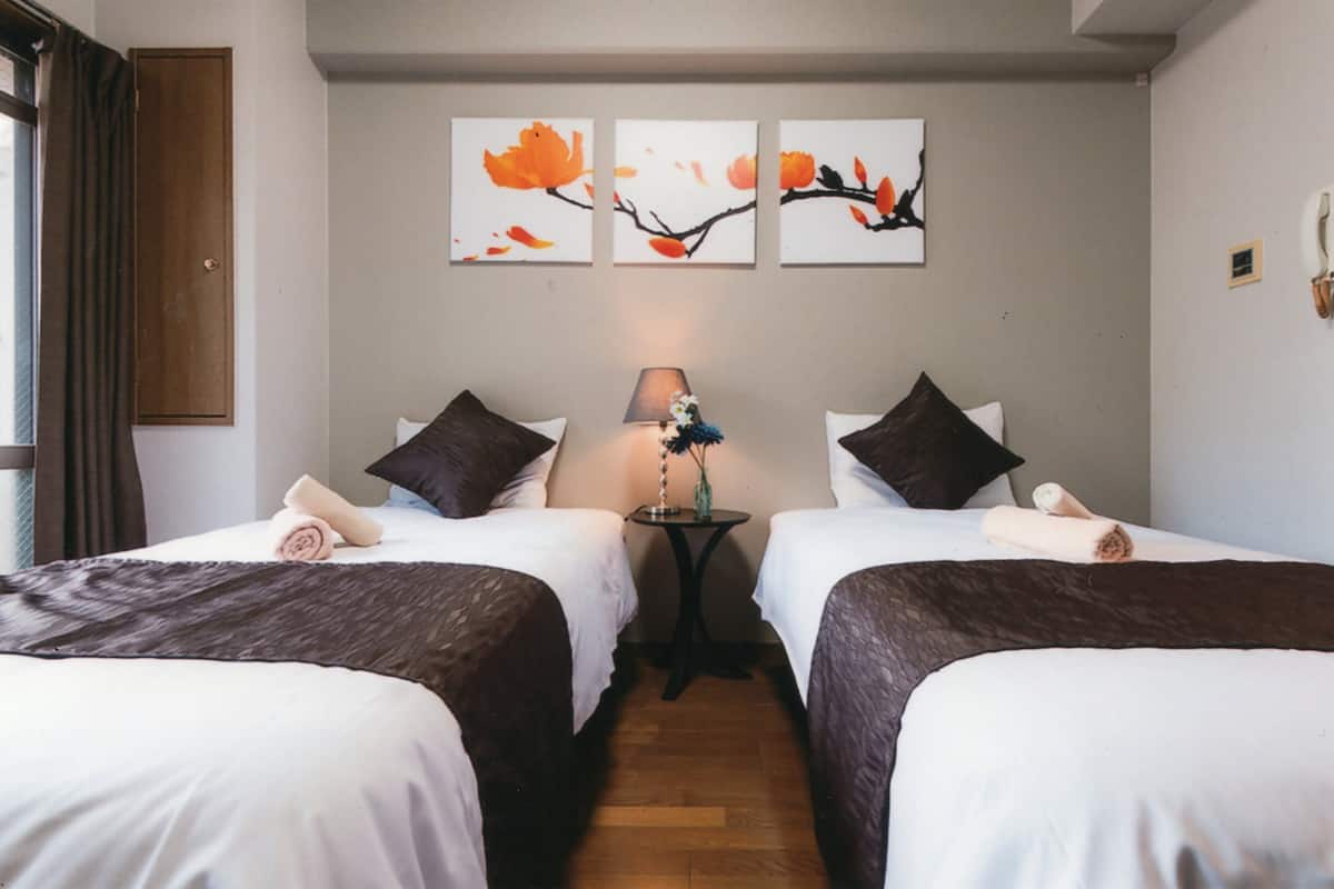 Een hotelkamer met twee bedden, een nachtkastje en wanddecoratie.