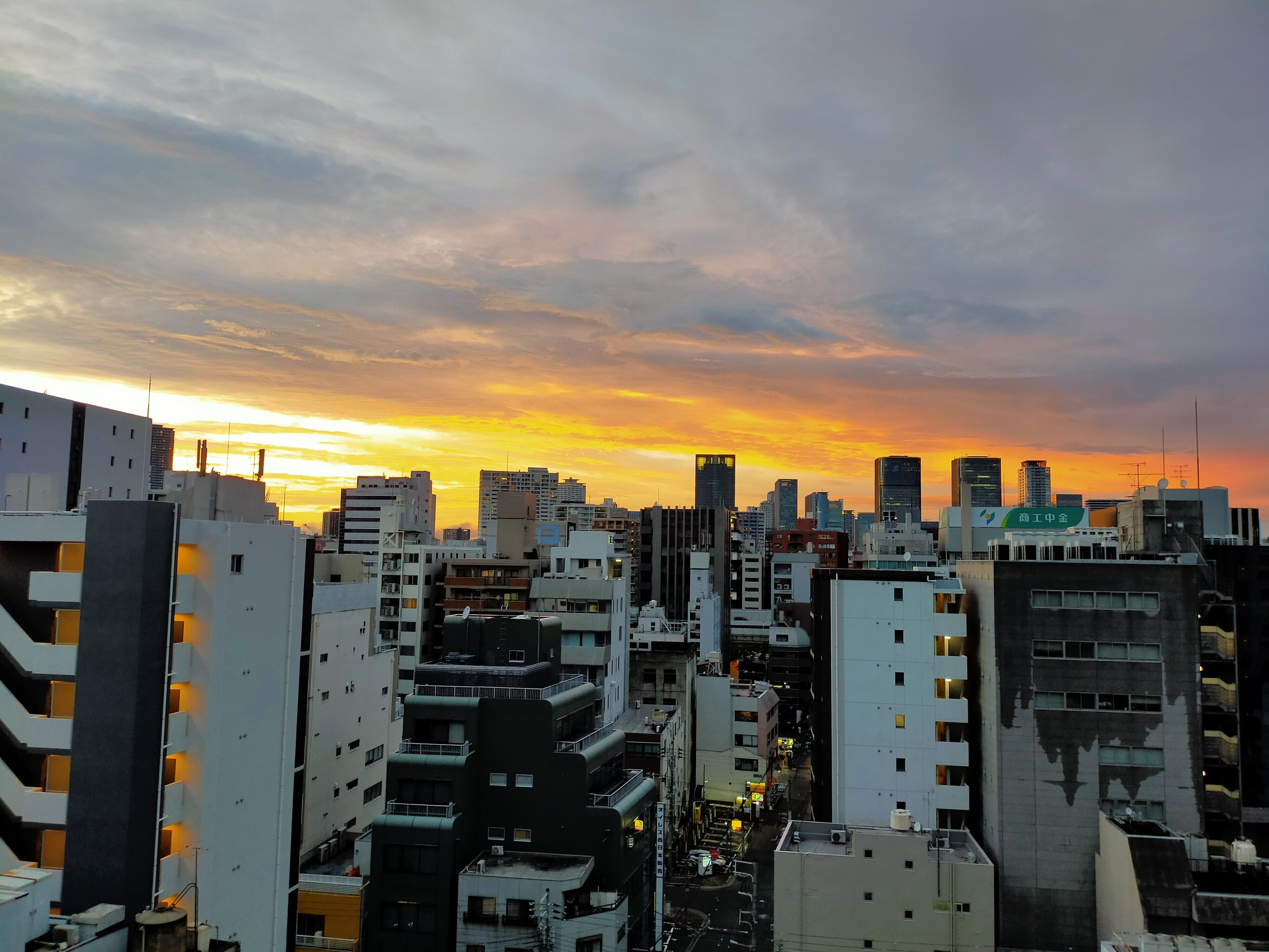 A dense urban skyline with high-rise buildings during sunset.