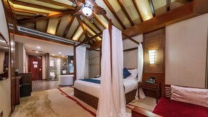 Une chambre à coucher avec un lit à baldaquin, un plafond en bois, une salle de bain et un petit bureau.