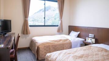 A hotel room with two beds, a desk with a television, a nightstand with a lamp, and a window with curtains.