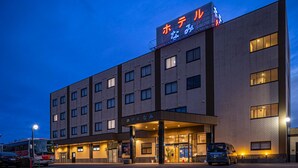 Un hotel con fachada de ladrillo moderno, múltiples ventanas y una entrada bien iluminada.