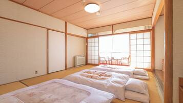 Una habitación japonesa tradicional con suelo de tatami, pantalla shoji y futón.