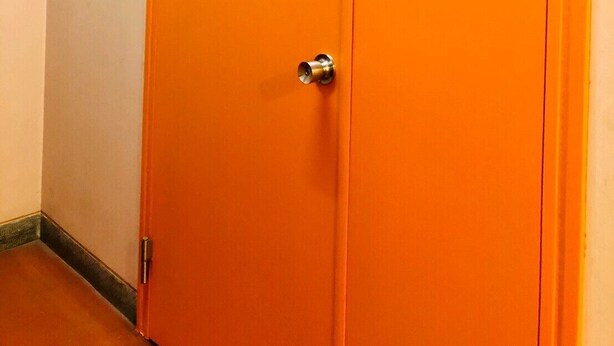 A closed orange door with a handle and a lock, and the text "bnb+" on it. - bnb Atami Resort - Hostel (Atami)