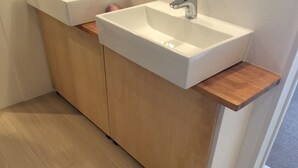A modern bathroom with a white sink, wooden cabinets, and a wooden countertop. - bnb Atami Resort - Hostel (Atami)