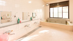 A bathroom with white tiled walls, a large window, a bathtub, and multiple sinks with mirrors. - Tabist Watanabe Chiba Ichinomiya (Ichinomiya)