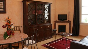Una sala de estar con comedor, un mueble de madera, una chimenea y un televisor.