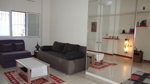 A modern living room with a sofa, a small table, and a glass partition. - Apartment at Lykavitos 1 bed 2 pers (Athens)