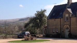 A stone building with a traditional design, a driveway, and a car parked in front. - Westgate Manor (Bishop Auckland)