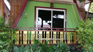 Un bâtiment écologique doté d’un balcon et d’une grande fenêtre.