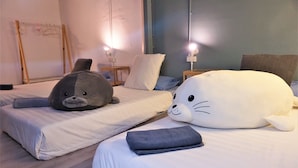 To senge med bløde dyrepuder, trægulv og sengeborde med lamper.