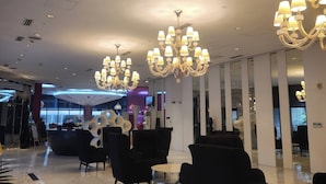 A modern lobby with chandeliers, black seating, and a reception desk. - Azure Staycation Philippines by AMRS Near Manila International Airport (Parañaque)
