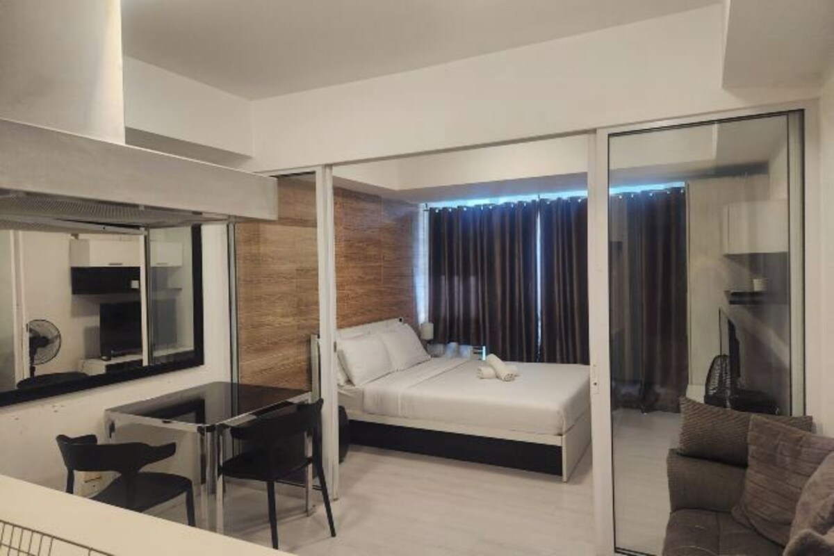 Una habitación de hotel moderna con una cama, un escritorio y una silla.