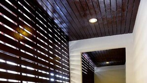 A modern interior with a polished floor, a wooden ceiling, and a wall with horizontal slats. - My Living Place Samui (Koh Samui)