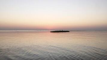 A calm sea with a small island in the distance.