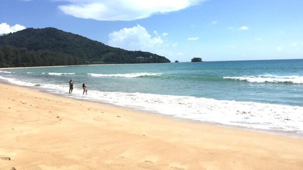 A beach with clear skies, calm waters, and a forested hill in the background. - Vacation Time House (Sa Khu)