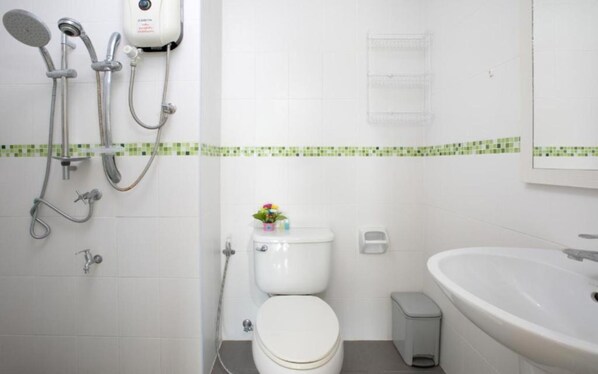 A bathroom with a toilet, a sink, and a shower with multiple shower heads. - Backpacker Street Airport Place (Sa Khu)