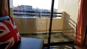 A balcony with a view of buildings and construction in the background.
