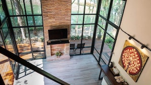 Un interior moderno con chimenea, ventanas amplias y un comedor.