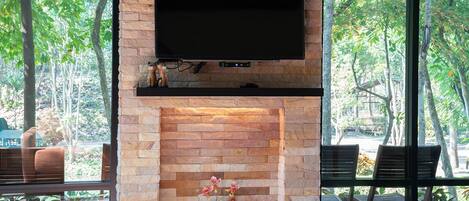 Una chimenea con un televisor de pantalla plana montado arriba, rodeada por un muro de ladrillo.