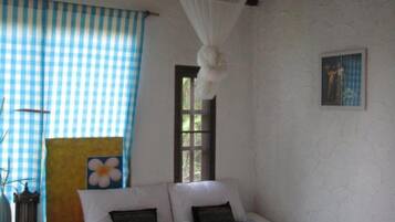Un dormitorio con cama, ventana y mosquitero.