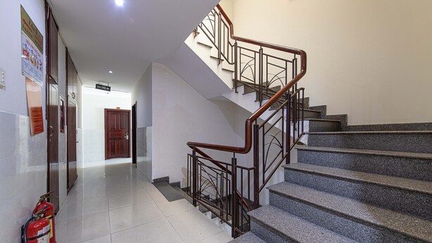 A staircase with metal railings and wooden handrails, leading to an upper floor. - Phong Lan 2 Hotel (Ho Chi Minh City)