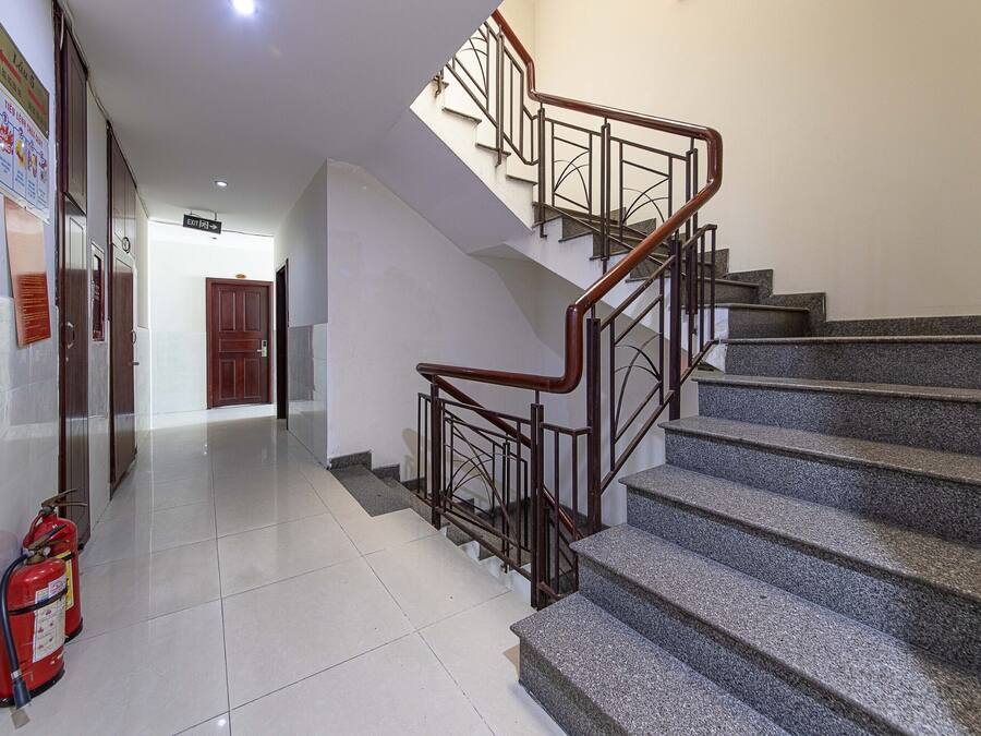 Una escalera con barandales de metal y pasamanos de madera, que conduce a un piso superior.