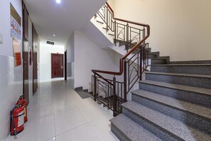 Una escalera con barandales de metal y pasamanos de madera, que conduce a un piso superior.