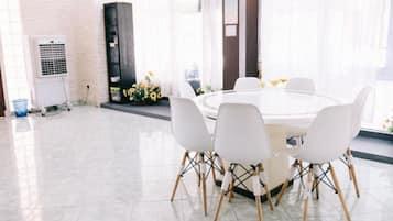Un espace repas moderne avec une table ronde et des chaises blanches.