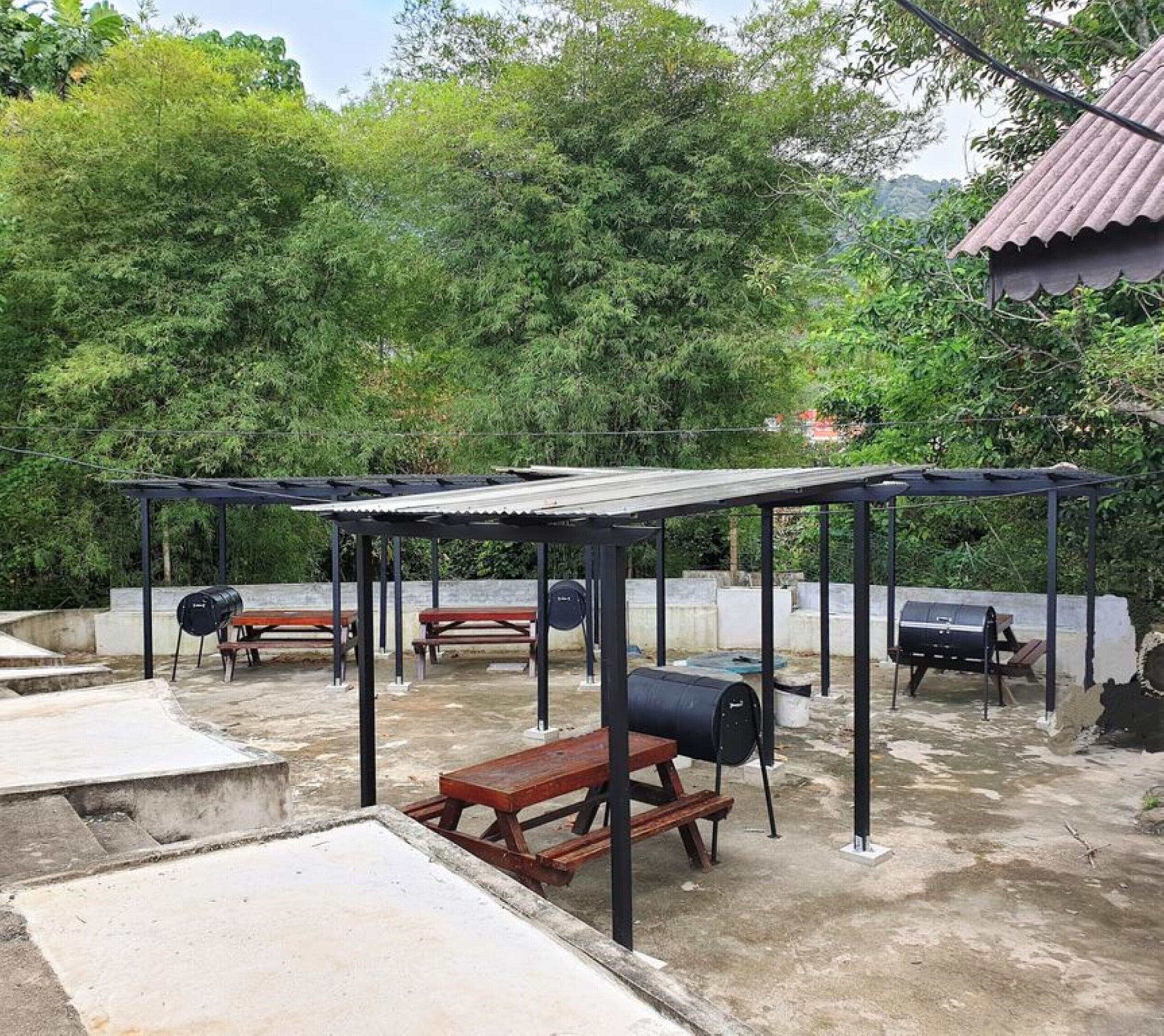 An outdoor patio area with picnic tables and barbecue grills.