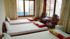 Une chambre d’hôtel avec deux lits, une petite table et une chaise.