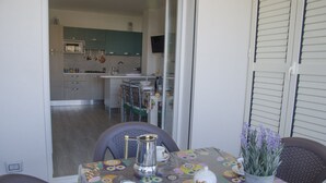 En matplats med ett bord dukat för två personer, en kaffekanna, koppar och en vas med blommor.
