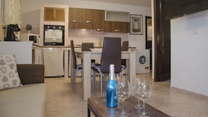A compact living space with a kitchenette, dining area, and a sofa. - Casa Valverde (Alghero)