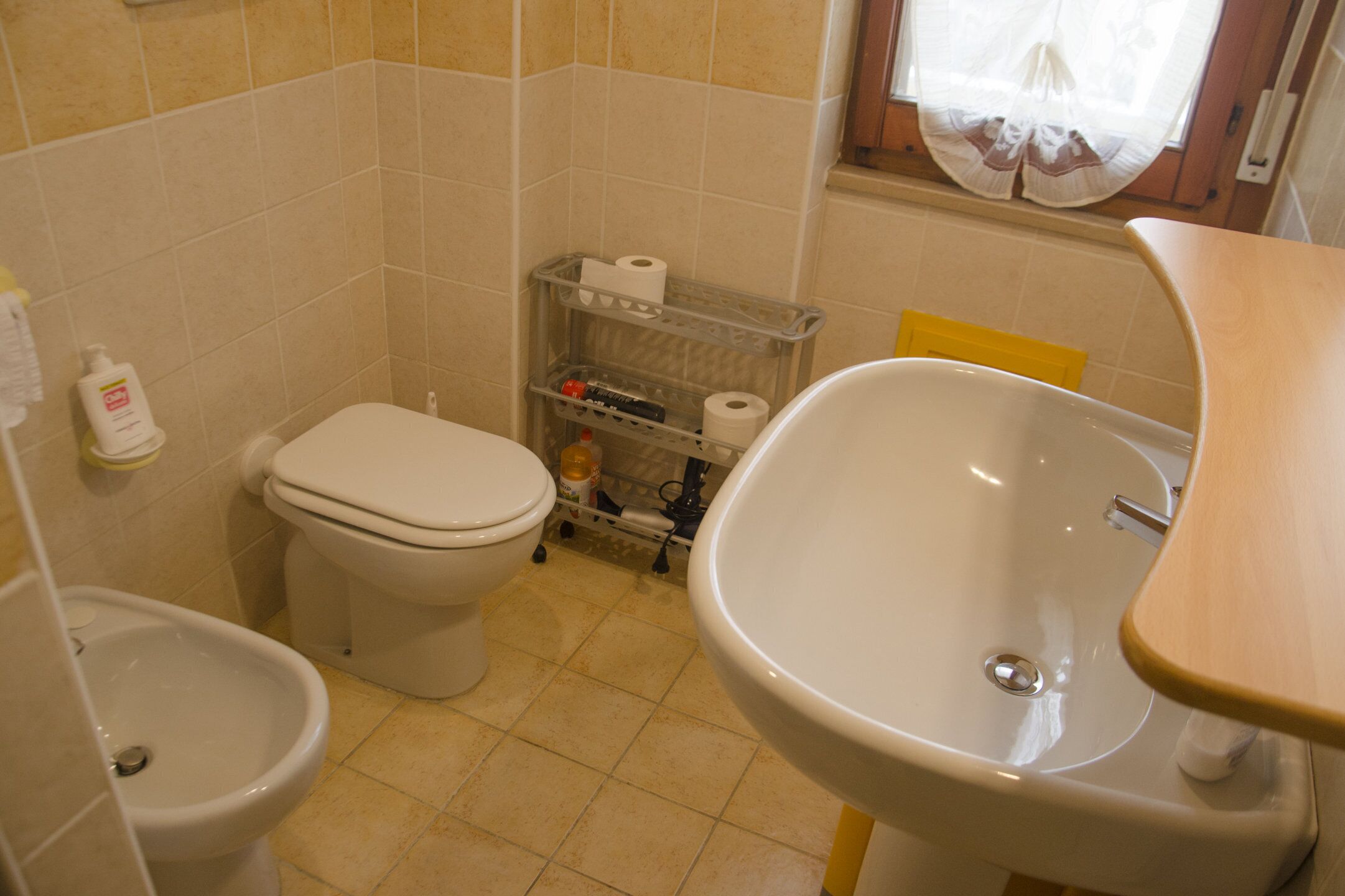 A compact bathroom with a toilet, bidet, and sink.