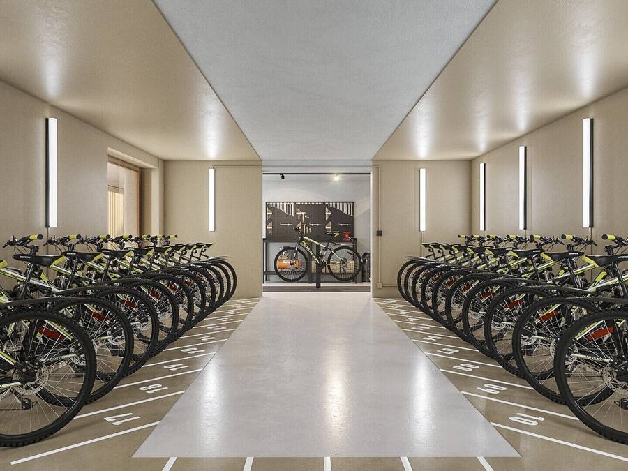 A bike rental station with rows of bicycles, a clean floor, and a modern interior design.