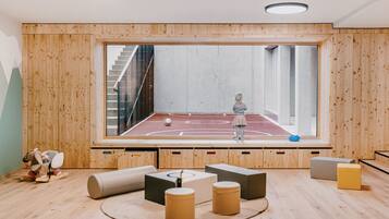 Una habitación con un ventanal grande, paredes de madera, una cancha de baloncesto y varios muebles.
