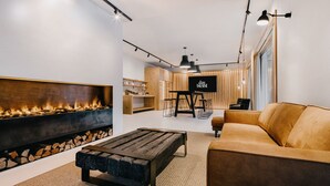 A modern living room with a fireplace, a sofa, and a TV. - das bleibt (Schladming)