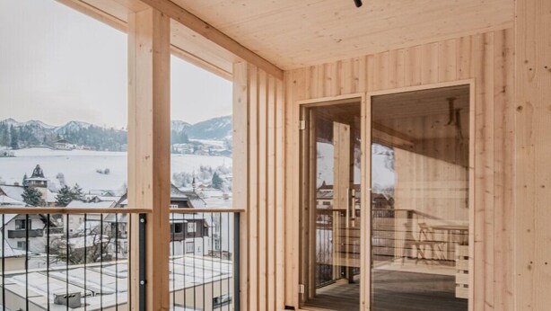 A wooden deck with a glass balustrade overlooking a snowy landscape. - das bleibt (Schladming)
