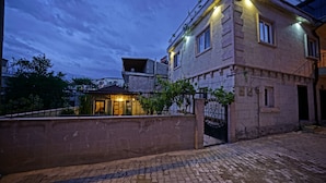 A two-story building with a balcony, a gated entrance, and a paved courtyard. - Epoch Stone House (Nevsehir)