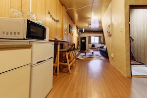 Enjoy casual dining at this kitchen with a dining table and chairs, microwave, and refrigerator.