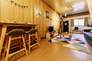 Cozy living space with a dining area, sofa, and television.