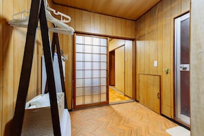 Traditional Japanese-style room with sliding shoji screen door and herringbone-patterned floor.
