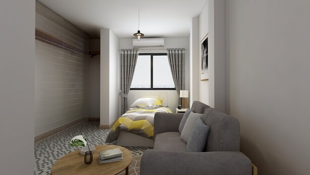 A modern bedroom with a bed, a grey sofa, a round wooden table, and a window with curtains.