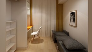 A modern, compact room with a built-in bench, a white chair, and a wooden desk.