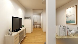 A modern living room with a flat-screen TV, a white cabinet, and a bookshelf with books and a decorative bird.