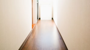 A narrow hallway with wooden flooring and light-colored walls. - TSURUYA (Osaka)