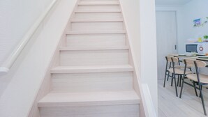 A staircase with light wood steps leading to a landing. - NICE HOUSE (Osaka)