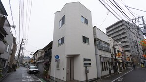 A narrow urban street with a white building featuring a small entrance and a blue sign. - MARE HOUSE-1F (Tokyo)