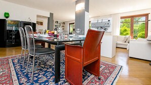 Un espace repas moderne avec une table en verre, des chaises en métal et un tapis à motifs.