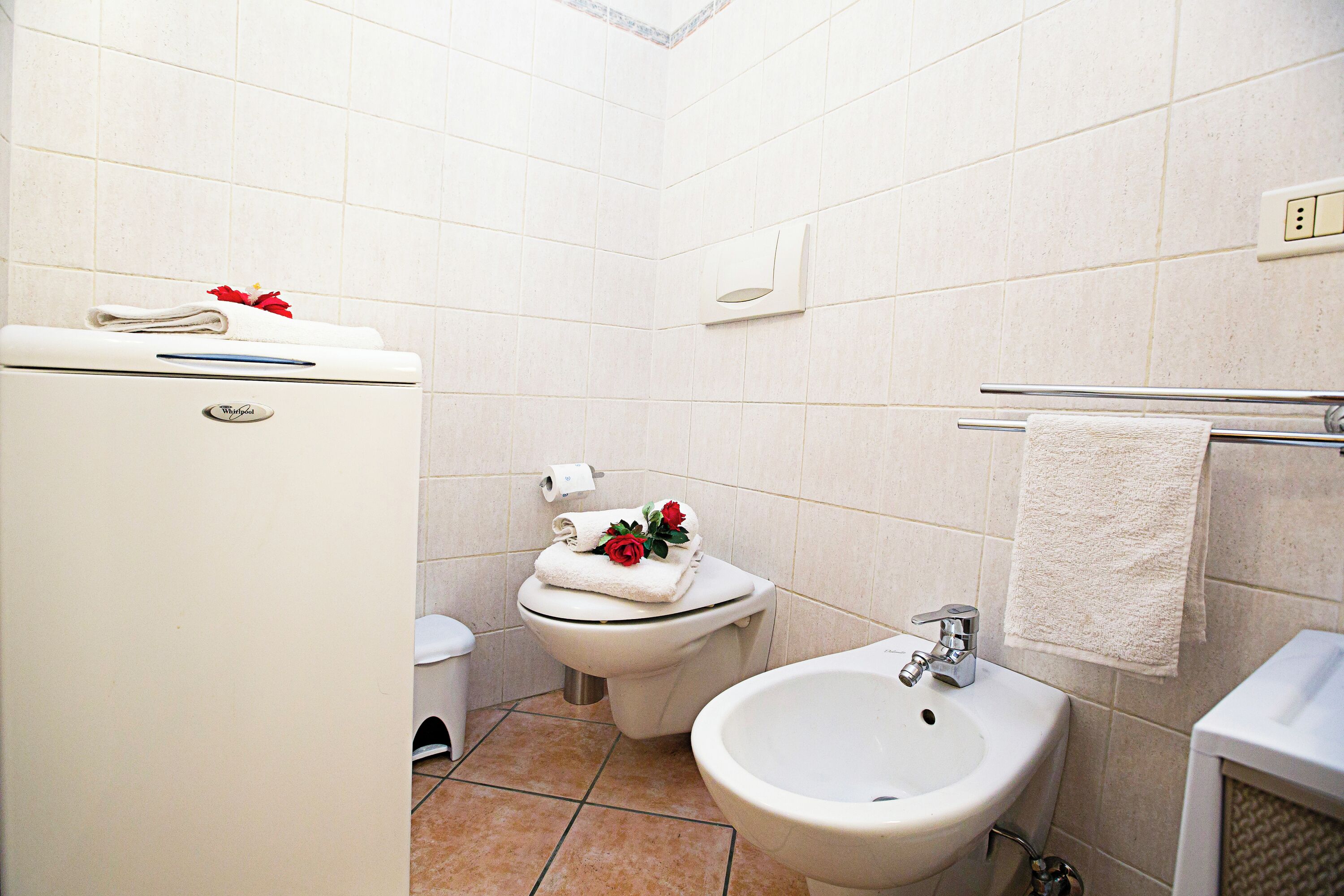 Een badkamer met een toilet, bidet en wastafel.