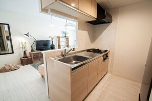 Kylskåp, mikrovågsugn, spishäll och grytor/köksredskap